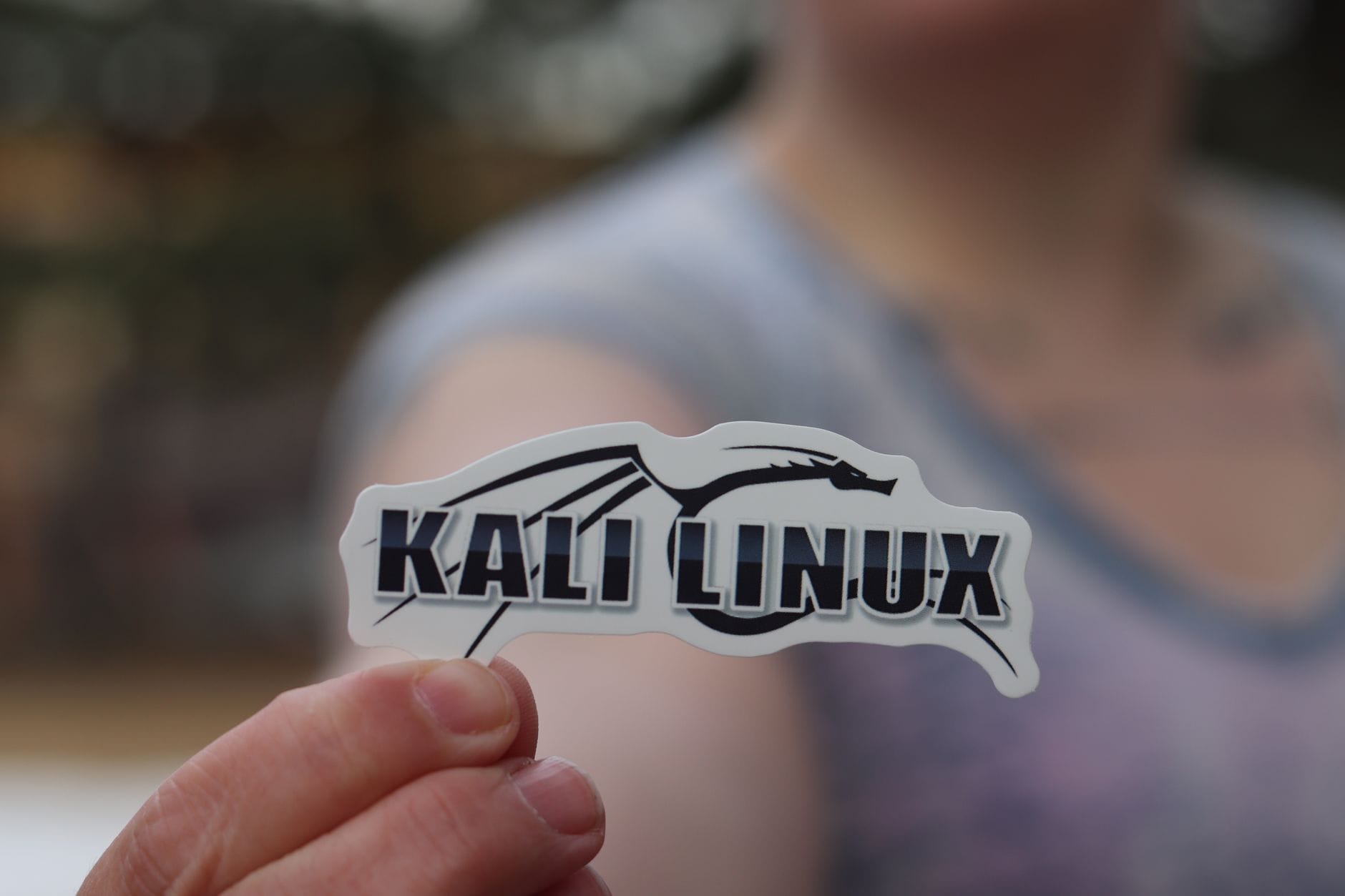 Bezpieczna i komfortowa jazda autostradą: praktyczne porady dla kierowców planujących długie trasy po Europie Dłoń trzymająca naklejkę Kali Linux symbolizującą cyberbezpieczeństwo