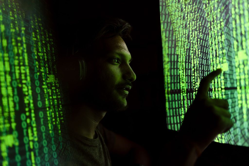 Osoba analizująca kod na ekranie w kontekście cyberbezpieczeństwa